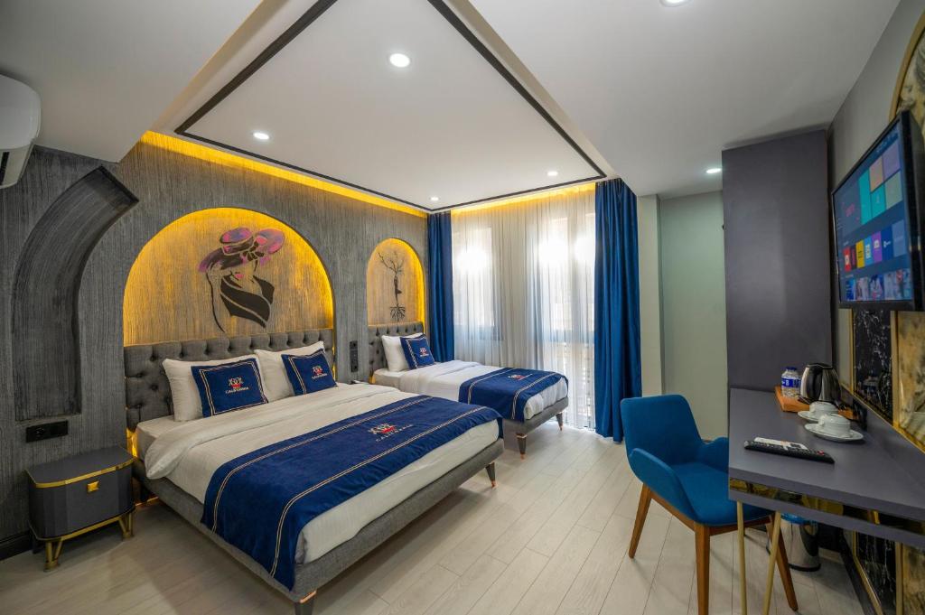 イスタンブールにあるホテル カリフォルニアのベッド2台とデスクが備わるホテルルームです。