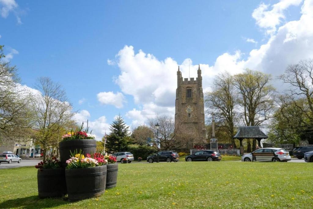 eine Kirche mit einem Uhrturm in einem Park in der Unterkunft Hardwick Haven, Sedgefield - Near Hardwick Hall in Stockton-on-Tees