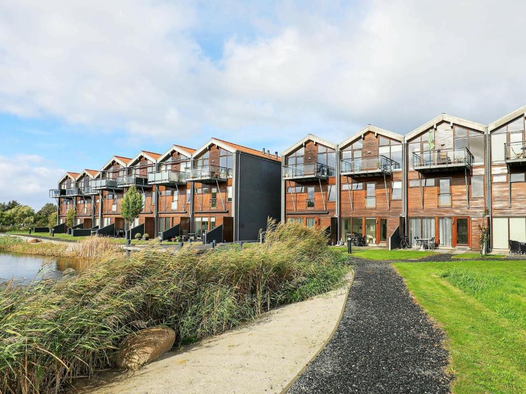ボーゲンセにある6 person holiday home in Bogenseの水の隣の一列のアパートビル