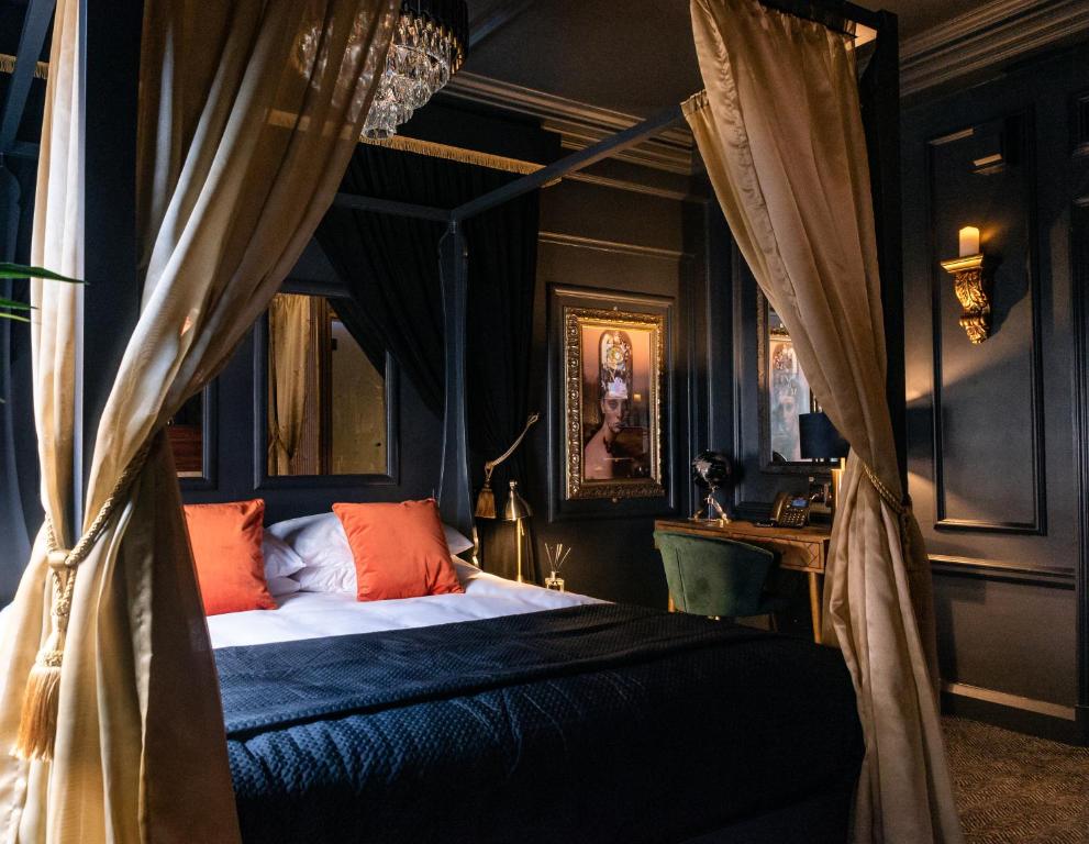 - une chambre avec un lit à baldaquin et des oreillers orange dans l'établissement Impossible Motel, à York