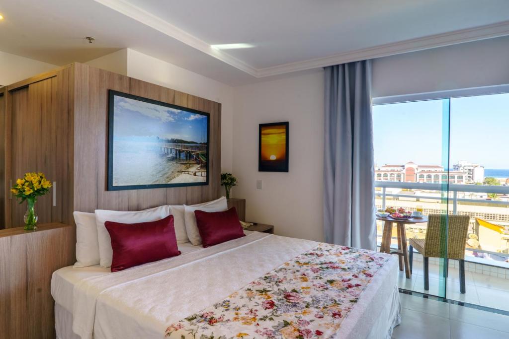 ein Schlafzimmer mit einem großen Bett und einem großen Fenster in der Unterkunft Oasis Cabo Frio in Cabo Frio