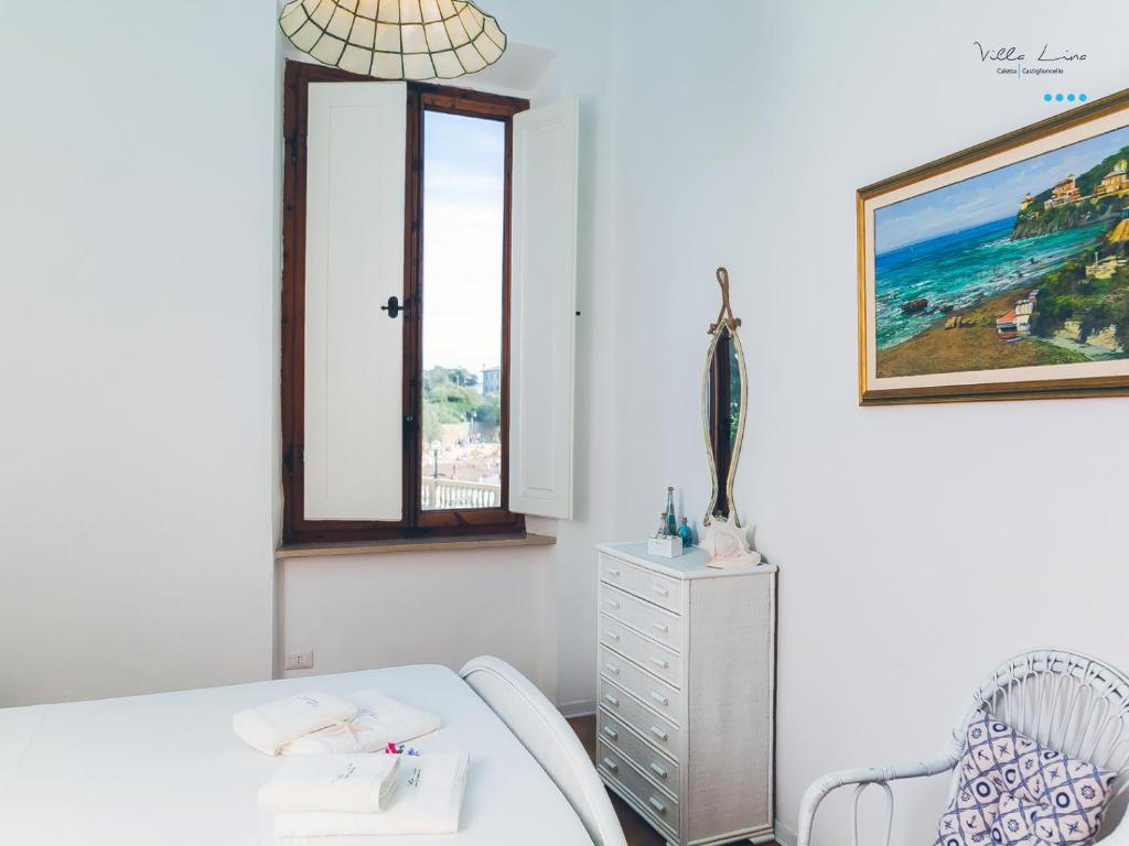 a bedroom with a bed and a dresser and a window at Villa Lina in Castiglioncello