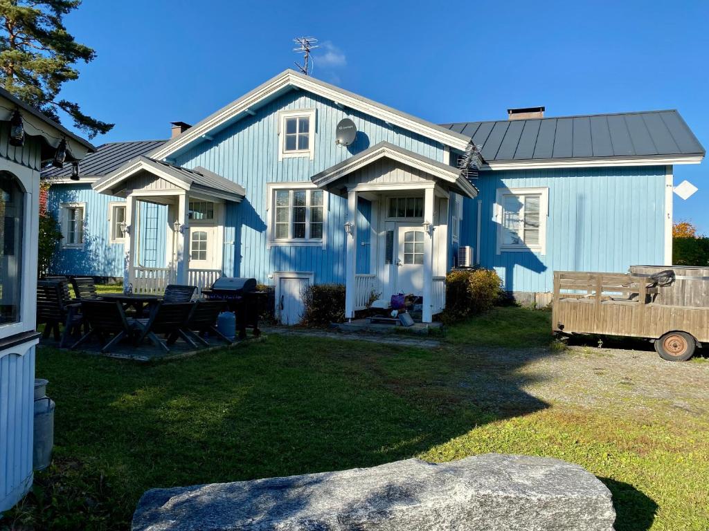 a blue house with a picnic table in the yard at Mäkisen Majatalo in Palus