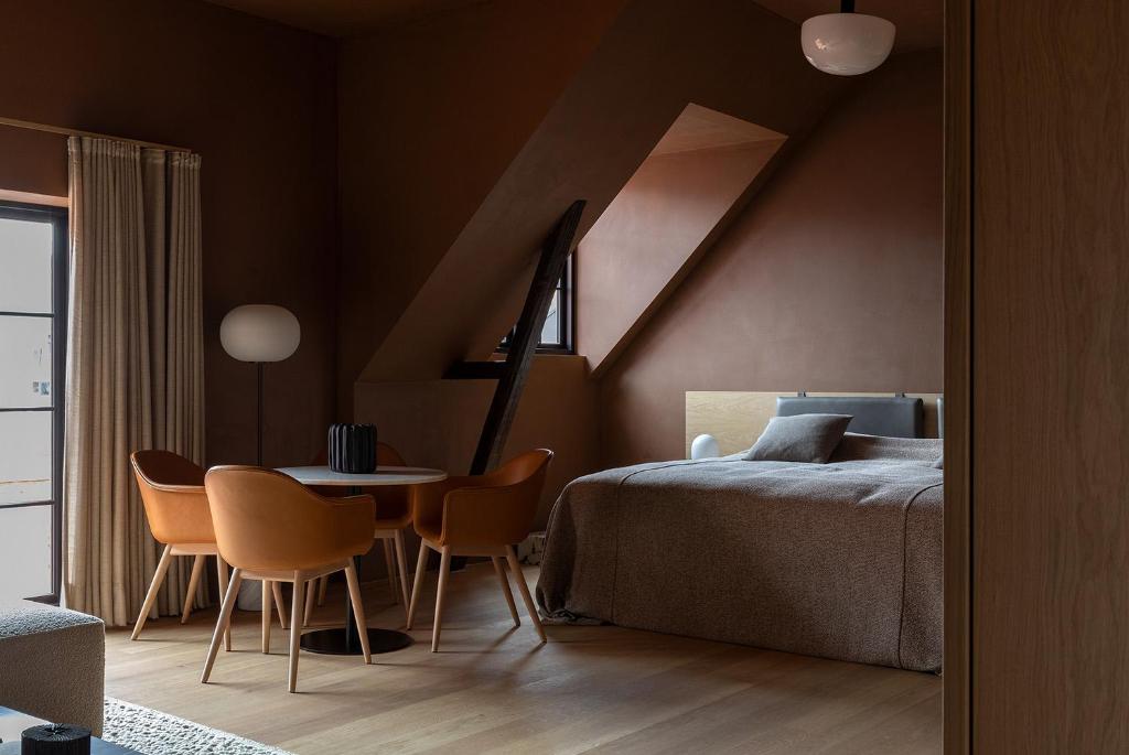 a bedroom with a bed and a table and chairs at Audo Copenhagen in Copenhagen