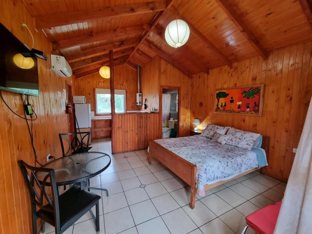San Fabián de AlicoにあるCabañas Nativaのベッドルーム1室(ベッド1台、テーブル付)