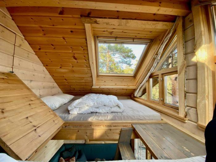 a small room with a bed in a wooden house at Tretopphytter På Grensen - Elghytta med robåt og gjeddefiske in Halden