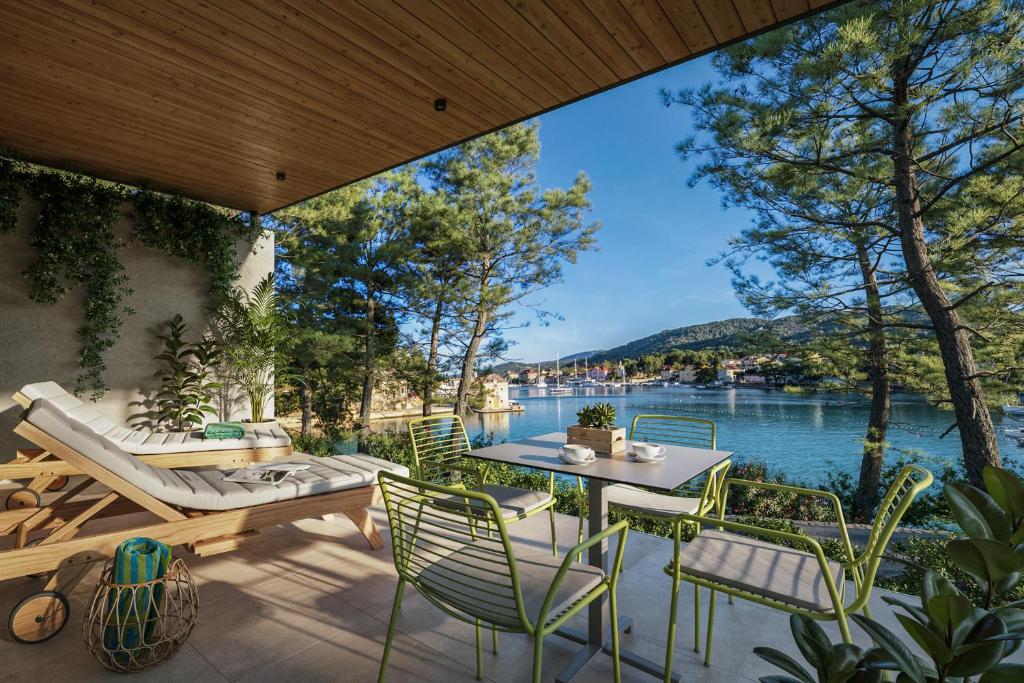 a patio with a table and chairs and a view of the water at Valamar Amicor Green Resort in Stari Grad