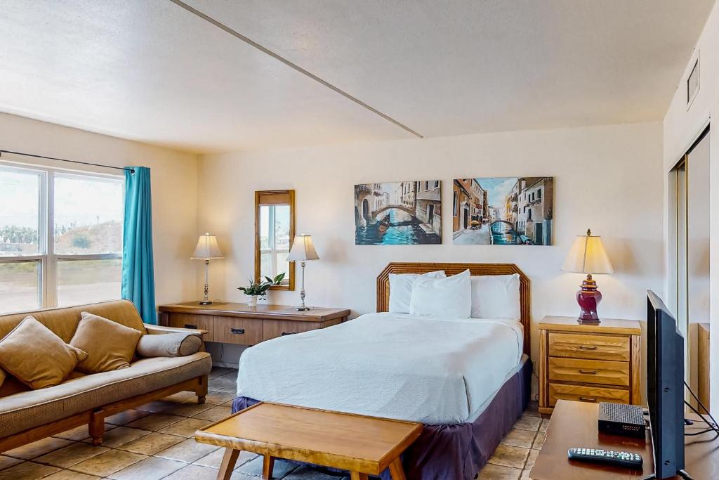 um quarto de hotel com uma cama e um sofá em Gulfview I #201 em South Padre Island