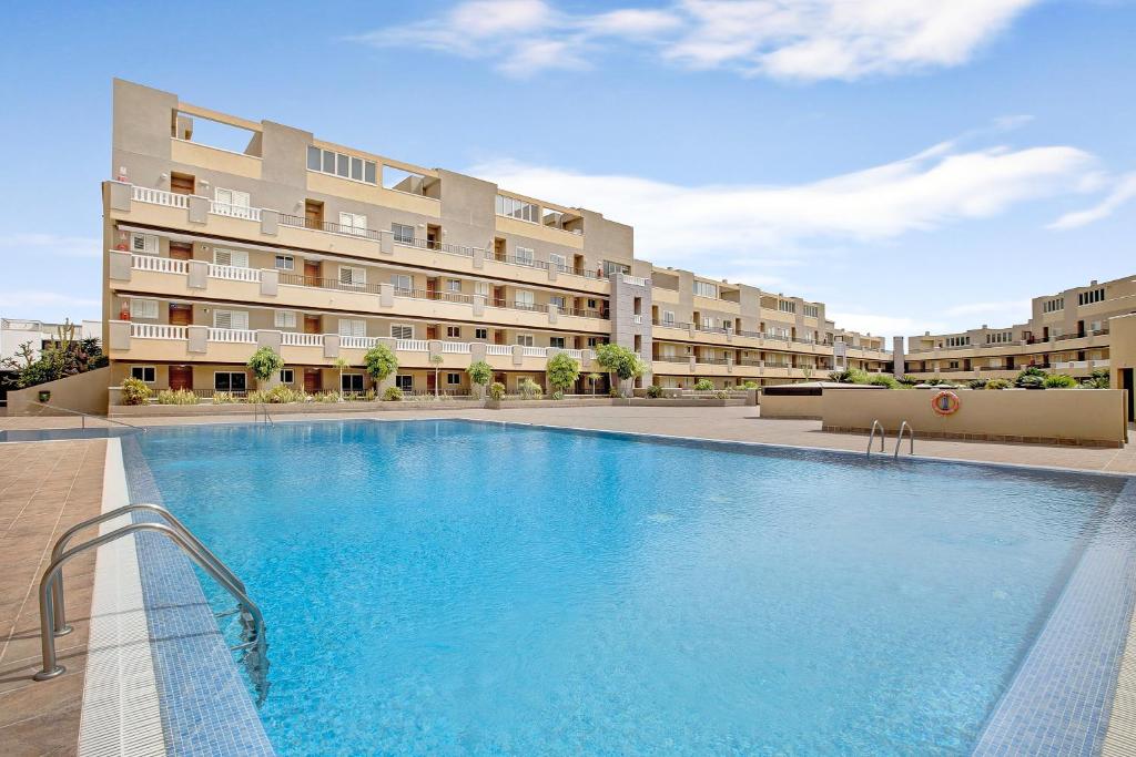 a large swimming pool in front of a building at La Perla D14 en el Médano in El Médano