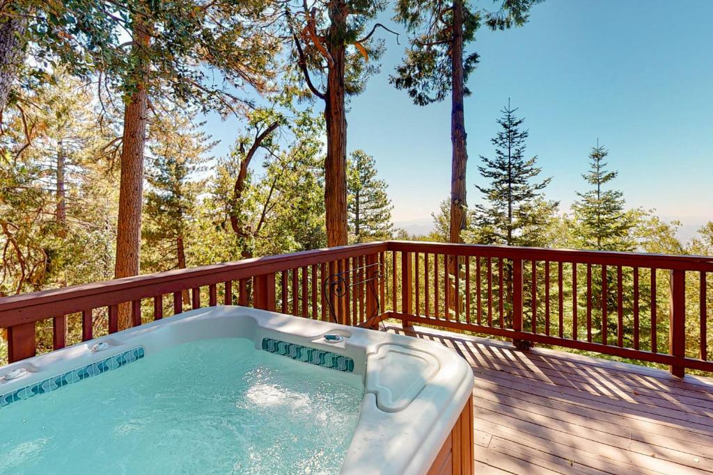 a hot tub on a wooden deck with trees at Deer Path Cabin in Idyllwild