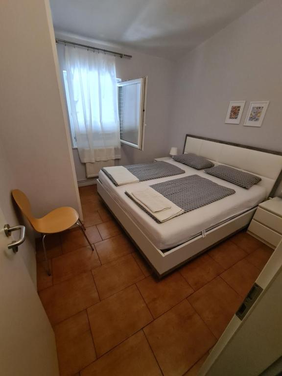 a bedroom with a bed and a chair in it at Apartma z dvema spalnicama in teraso in Portorož
