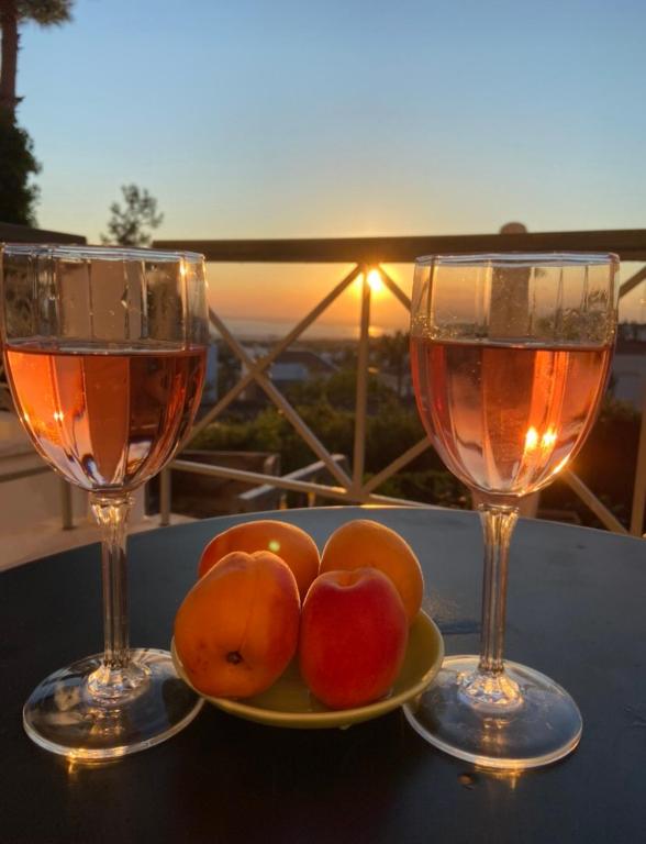 dois copos de vinho e um prato de fruta numa mesa em Respect to the Guest em Tessalónica