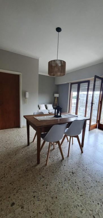 uma sala de estar com uma mesa de madeira e 2 cadeiras em Azul Alvear Suites em Azul