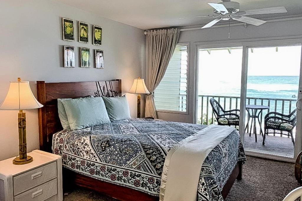 a bedroom with a bed with a view of the ocean at Kapa'a Sands 07 in Kapaa