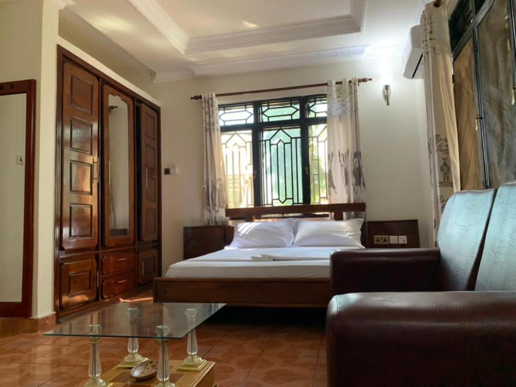 una camera con letto, finestra e divano di COAST VIEW RESORT a Kigoma