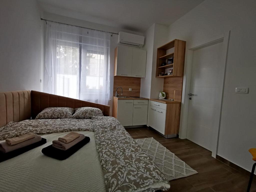 a small bedroom with two beds and a kitchen at LITTLE GARDEN - self CHECK IN in Osijek