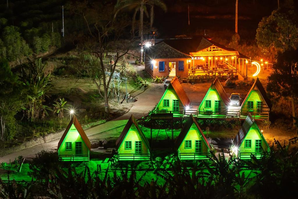a group of green homes at night at Pousada Recanto da Lua in Alto Caparao