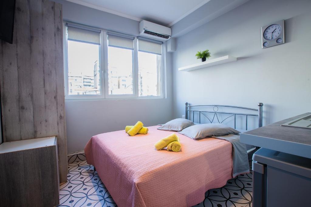 a bedroom with a bed with yellow towels on it at Modiano Studio ΙΙ By Socrates Junior Houses in Thessaloniki