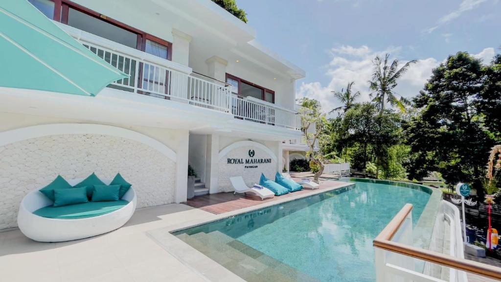 a villa with a swimming pool and a house at Royal Maharani Payogan in Ubud
