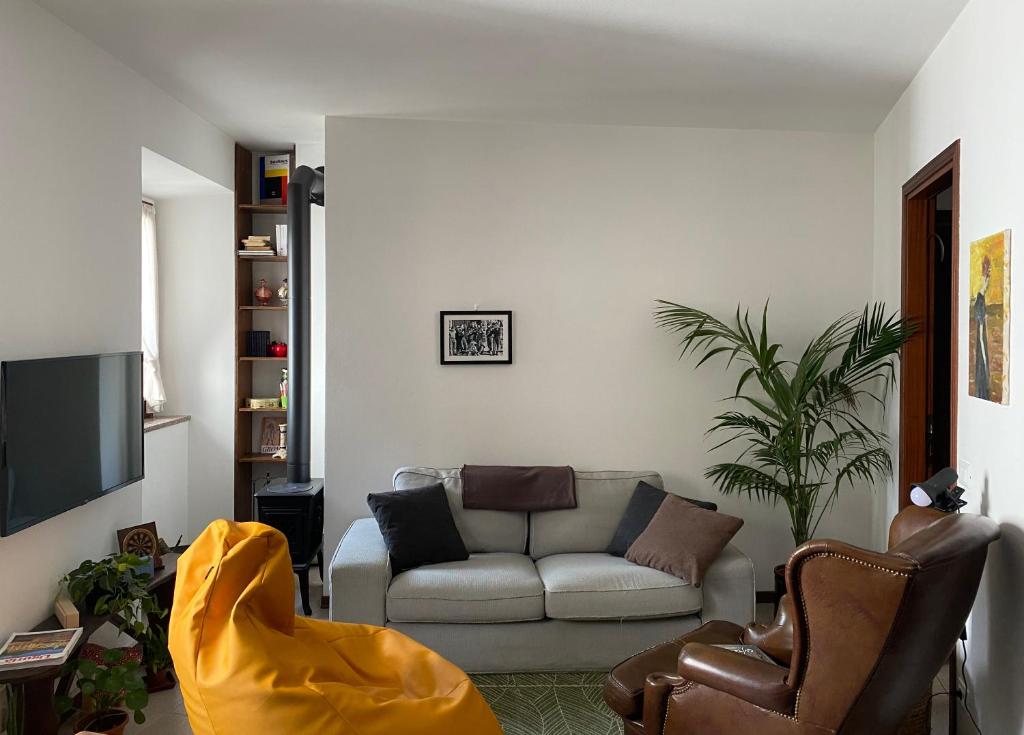 ein Wohnzimmer mit einem Sofa und einem TV in der Unterkunft Dagli Olivari - Casa Teo in Gromo