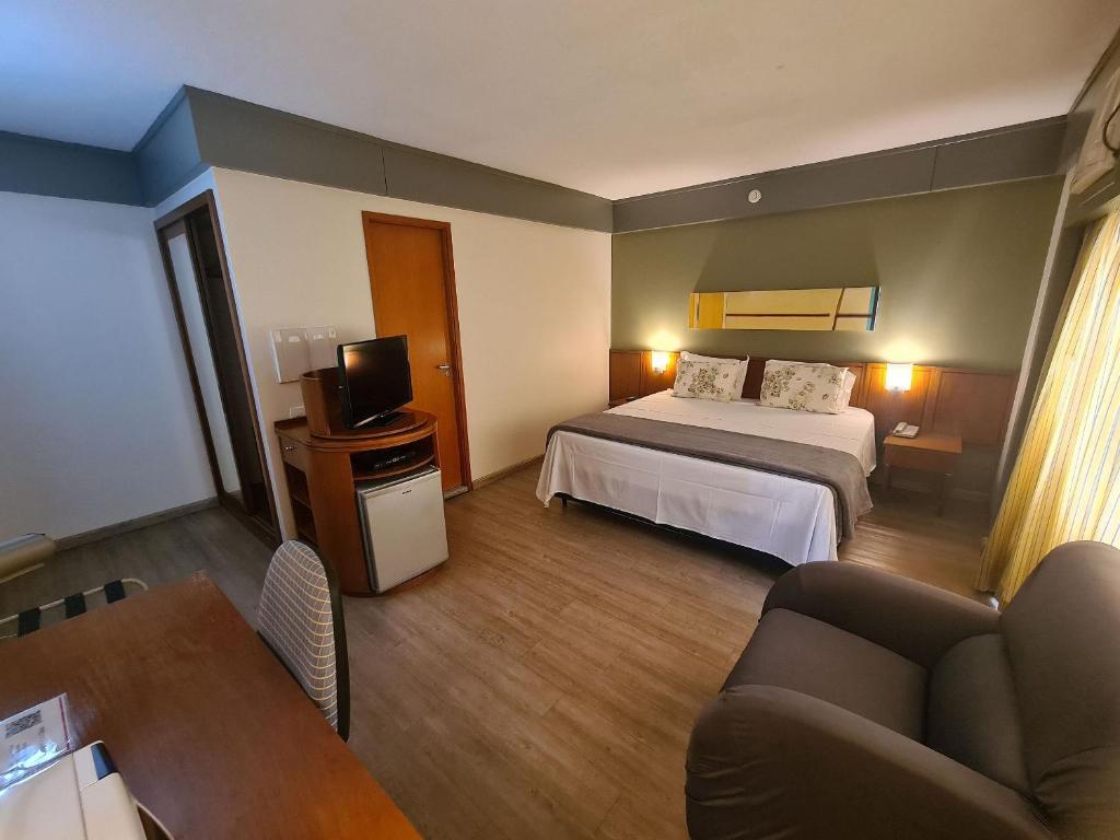 a hotel room with a bed and a television at Flat Borges Lagoa Ibirapuera c/ garagem UH508 in Sao Paulo