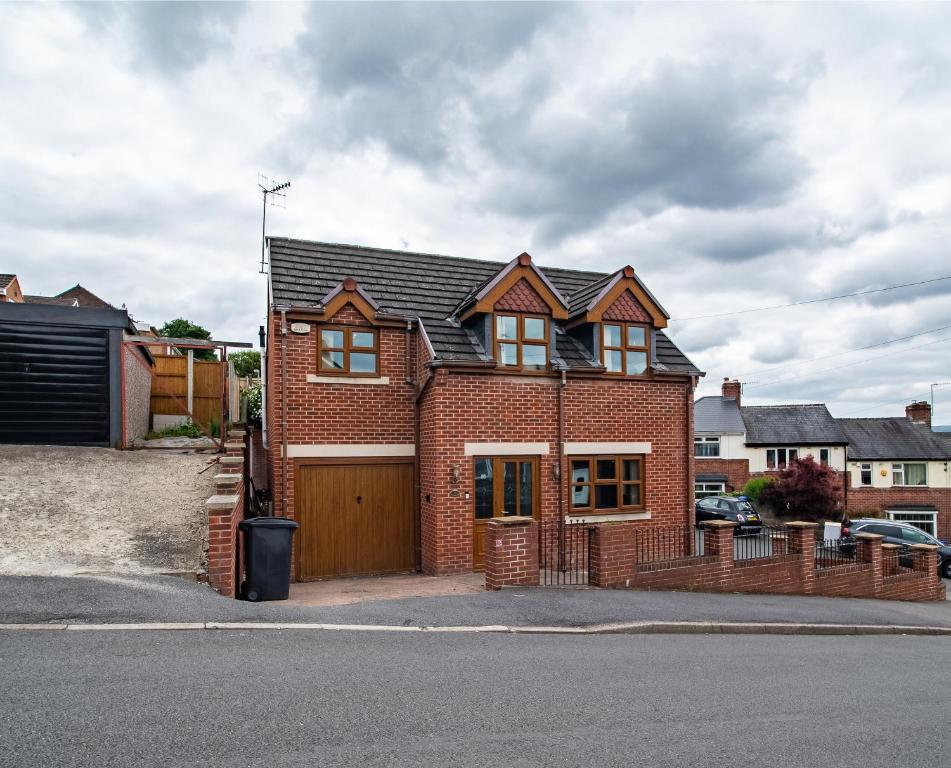 uma casa de tijolos vermelhos com garagem de madeira em Grandeur Homes Sheffield em Heeley