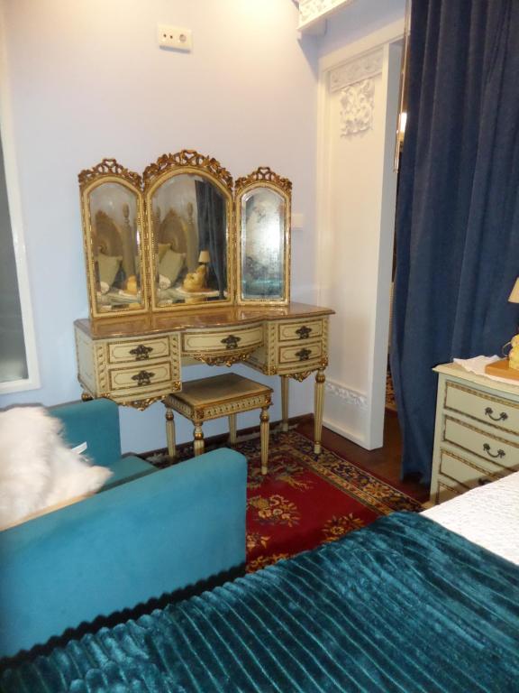 a bedroom with a dressing table and a blue couch at Casal de S.Romão do Meio in Guimarães