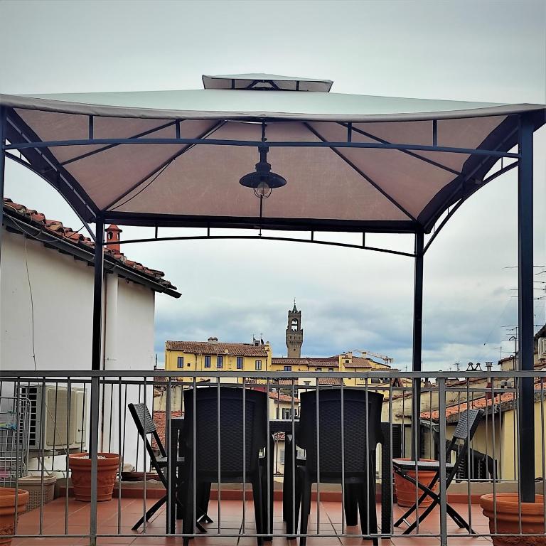 patio ze stołem i krzesłami na dachu w obiekcie ATTICO RUCELLAI CON TERRAZZA SUPER VISTA we Florencji