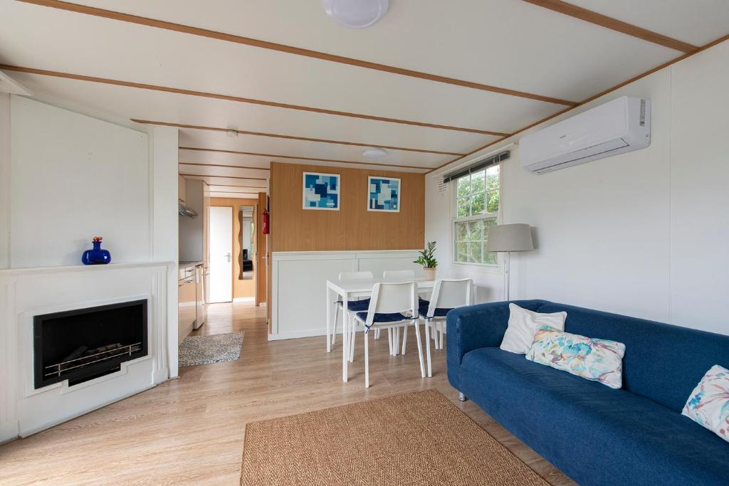 un soggiorno con divano blu e tavolo di 87, gelegen in het rustige & bosrijke Oisterwijk! a Oisterwijk