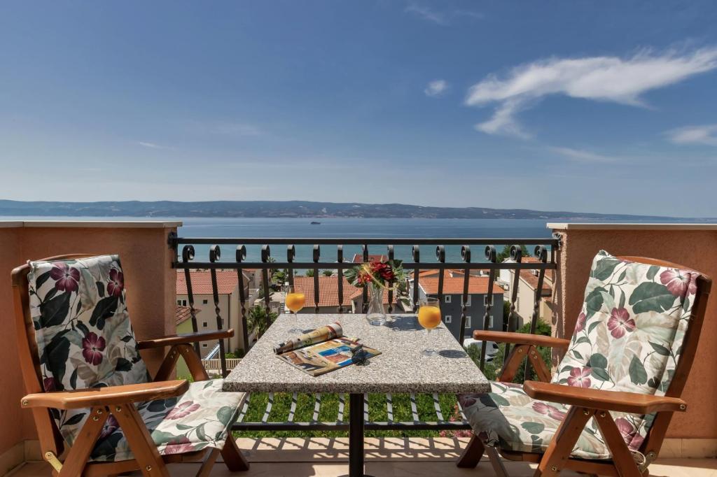 a table and chairs on a balcony with a view of the water at Room 79-7 in Duće