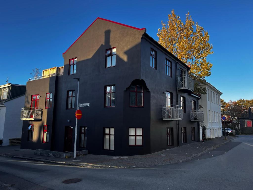 een zwart gebouw aan de straatkant bij Baldur Apartments in Reykjavík