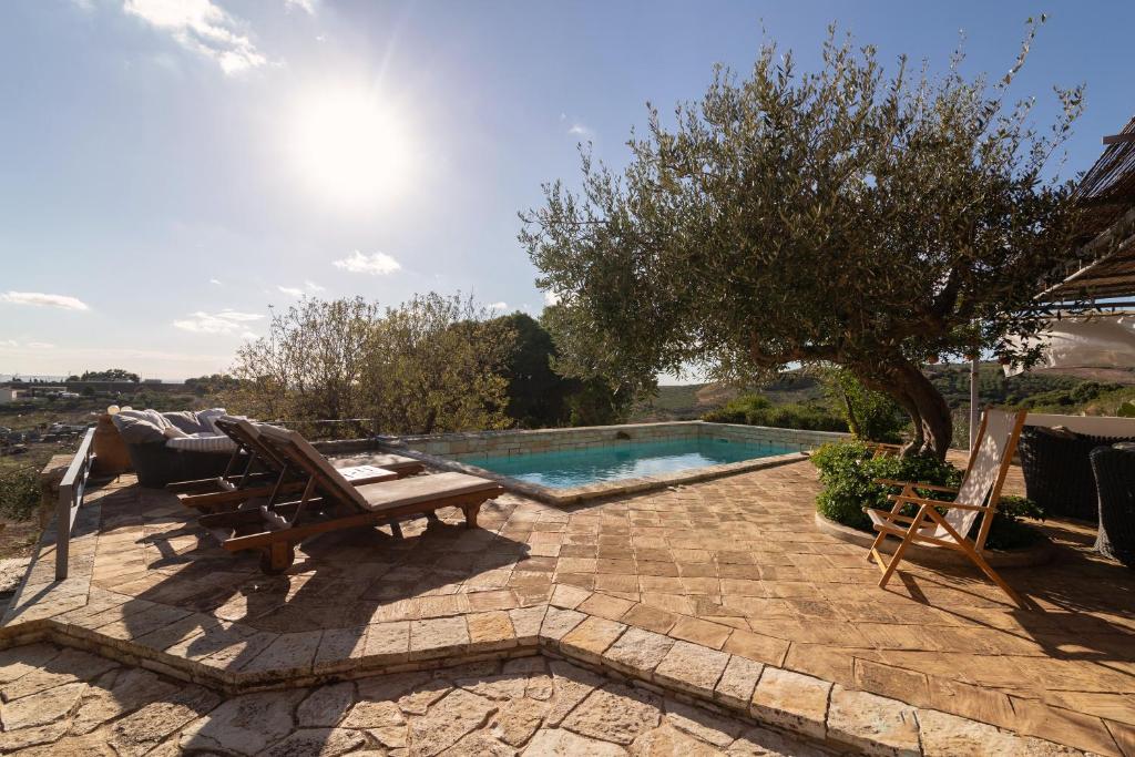 eine Terrasse mit Stühlen und einem Pool in der Unterkunft Covo D amuri in Erice