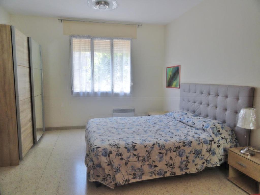 een slaapkamer met een groot bed en een raam bij Chez Mi, centre ville, parking gratuit, arrivée autonome in Saint-Chinian