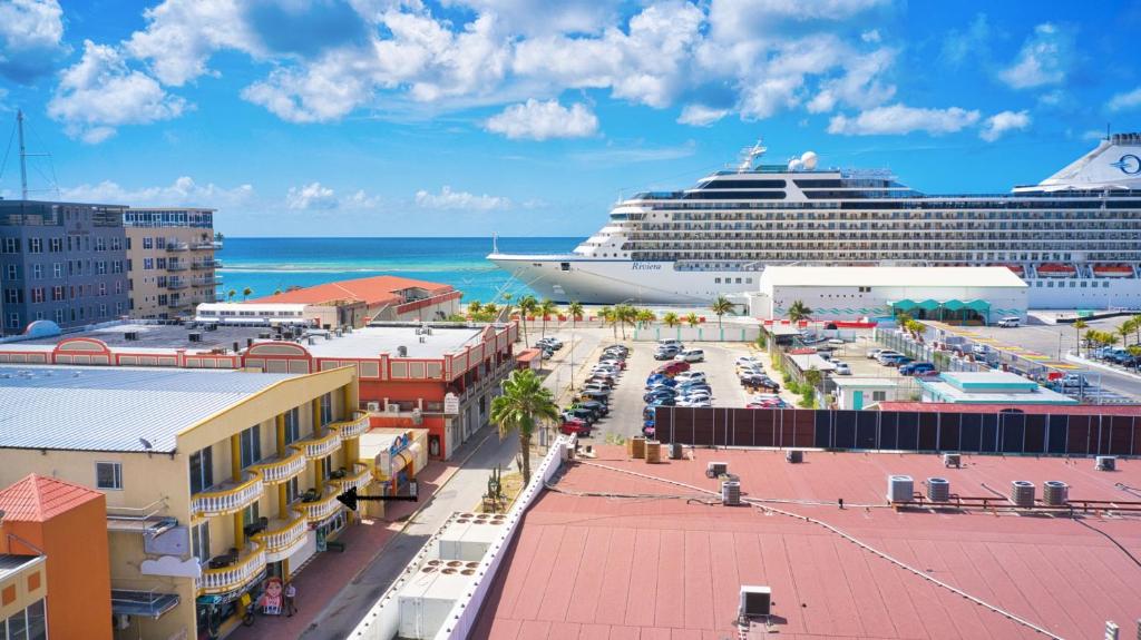 een cruiseschip is aangemeerd in een stad met gebouwen bij Bay Harbor Luxury 1 bedroom apartments in Oranjestad