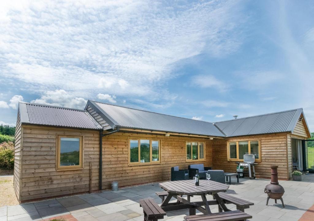 a wooden cabin with a picnic table in front of it at Caban Cwm Hedd in Bassaleg