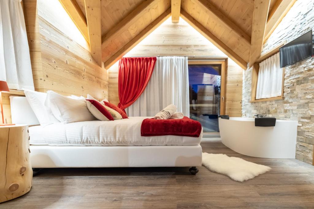 a bedroom with a bed and a tub in a room at Chalet Imbosc&#39;chè in Livigno