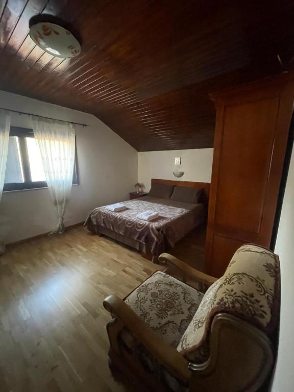 1 dormitorio con 1 cama, 1 sofá y 1 silla en CASUTA MAGICA, en Păuşeşti-Măglaşi