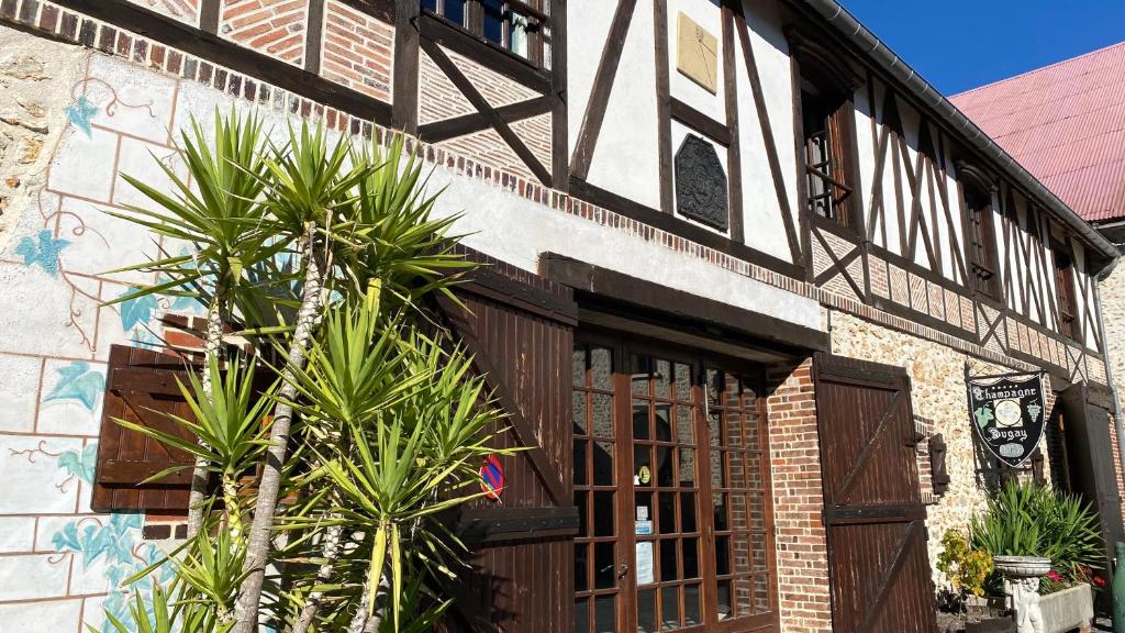 un bâtiment avec des palmiers en face de celui-ci dans l'établissement Domaine du Cellier de la Couronne, à Sézanne