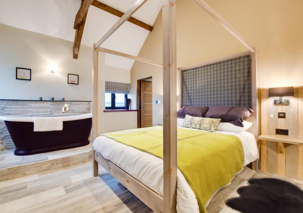 a bedroom with a bed and a bath tub at Tir Bach Iago in Llangwnadl