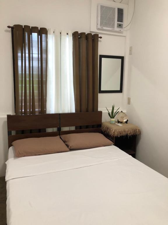 1 dormitorio con 1 cama blanca grande y ventana en Hiraya Homestay Coron en Corón