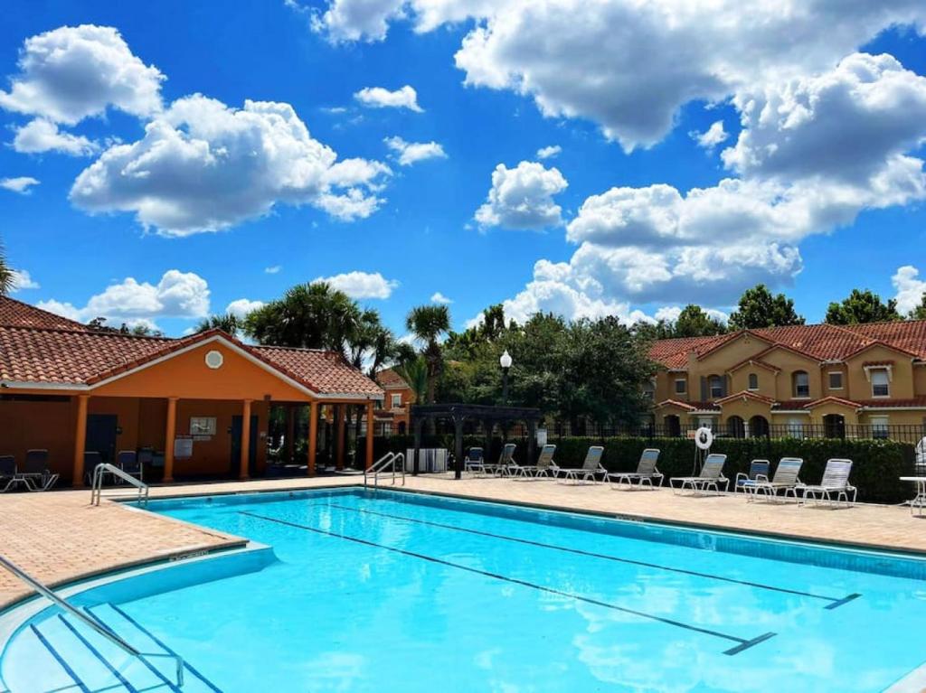 a swimming pool at a resort with chairs at 3BR Townhouse Next to Disney in Orlando
