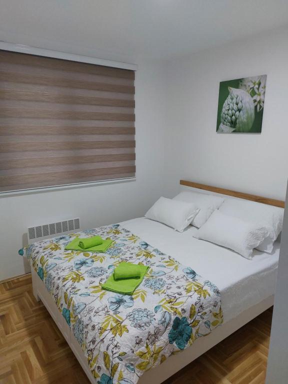 um quarto com uma cama com toalhas verdes em Stan na dan MB Istocno Sarajevo em Lukavica