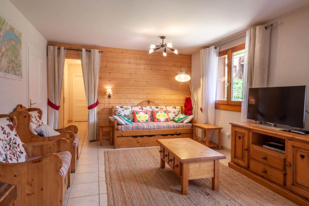 ein Wohnzimmer mit einem Sofa und einem TV in der Unterkunft JEANETTE 2 in Morzine