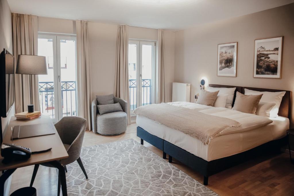 1 dormitorio con cama, escritorio y silla en Villa Bosco - Digitales Boutiquehotel, en Walldorf