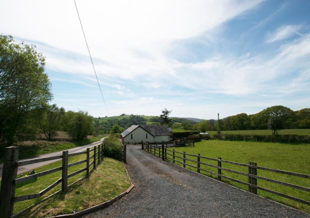 a road leading to a farm with a fence at Dan y Comin in Sennybridge