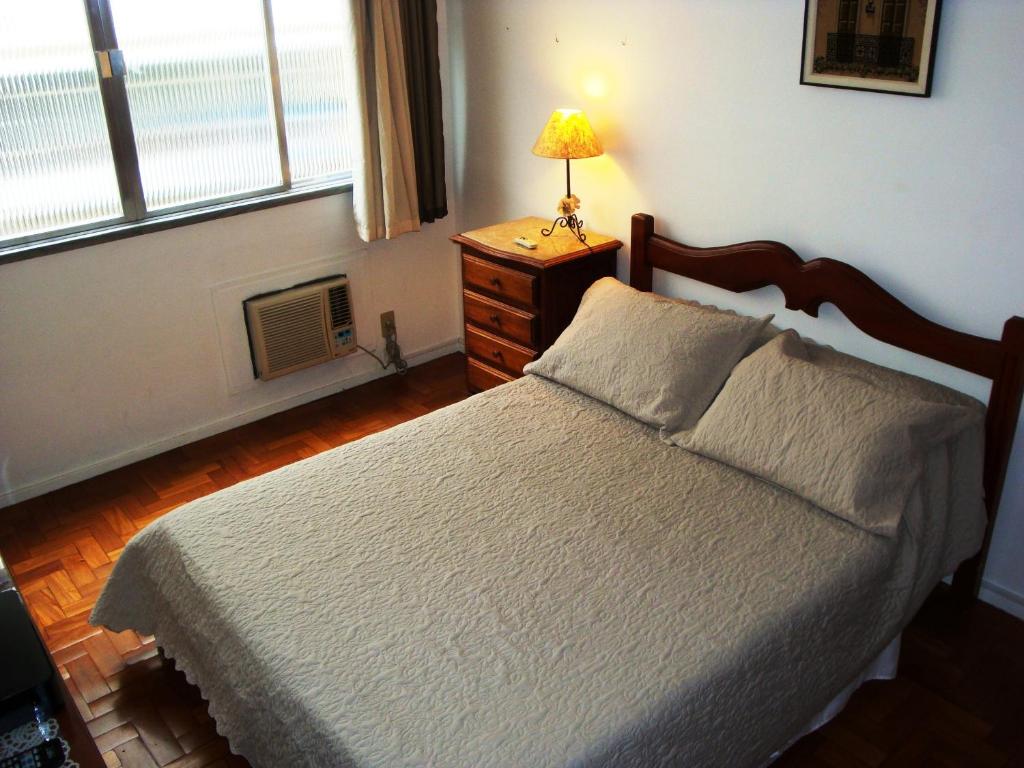Un dormitorio con una cama y una lámpara en un tocador en Apartamento Figueiredo Magalhães, en Río de Janeiro