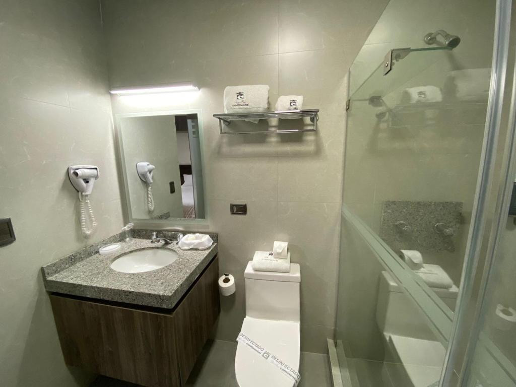 y baño con lavabo, ducha y aseo. en Gran Hotel Continental, en Cajamarca
