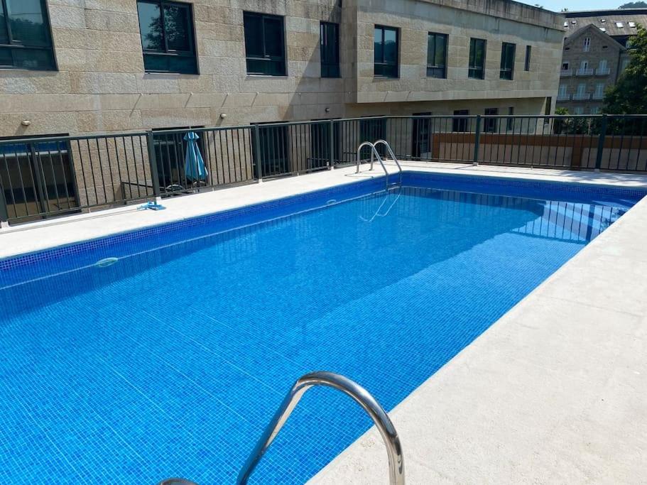 a large blue swimming pool in front of a building at Casa Amelia in Mondariz-Balneario