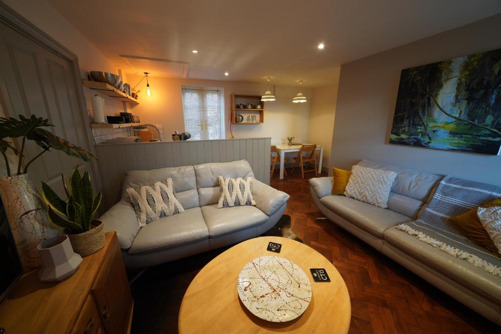 a living room with a couch and a table at Walmer, Deal stunning coach house apartment in Walmer