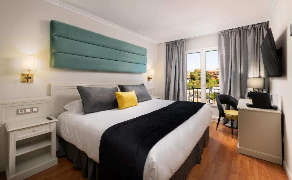 a hotel room with a large bed and a window at 1907 VILLA GIJON in Gijón